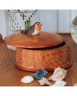 Runde Holzdose Rotkehlchen von Wildlife Garden mit geschnitzter Vogelfigur auf dem Deckel, dekoriert auf einem Holztisch mit Muscheln und Glasvase.