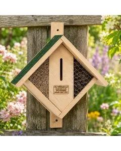 Insektenhotel aus Holz mit Bambus, Rinde, Metallgitter und grünem Dachfilz. Mehrere Nist- und Rückzugsbereiche für Wildbienen und Nützlinge.