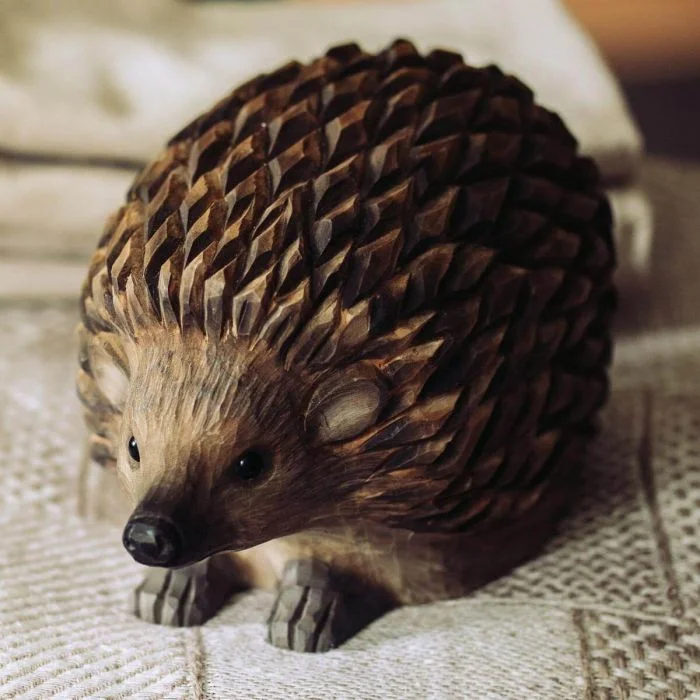 Handgeschnitzter DecoAnimal Igel aus Holz. Naturgetreu gestaltet und von Hand bemalt, mit markanter Stachelstruktur und kompakter Form.