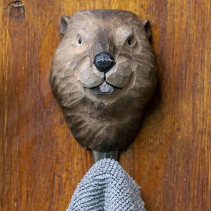 Kleiderhaken Biber von Wildlife Garden aus handgeschnitztem Holz. Mit typischen Schneidezähnen, feiner Fellstruktur und bronzefarbenem Metallhaken.