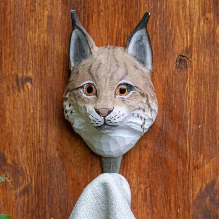 Kleiderhaken Luchs von Wildlife Garden aus handgeschnitztem Holz. Mit Glasaugen, schwarzen Ohrpinseln und bronzefarbenem Metallhaken.