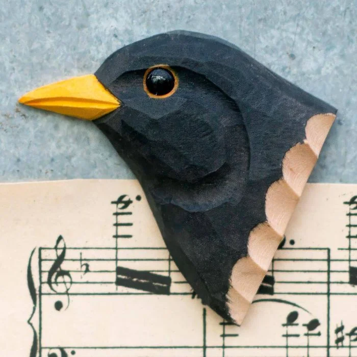 Ein Kühlschrankmagnet mit naturgetreu dargestelltem Vogelkopf, von Hand geschnitzt und bemalt.