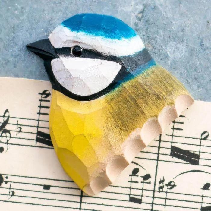 Ein Kühlschrankmagnet mit naturgetreu dargestelltem Vogelkopf, von Hand geschnitzt und bemalt.