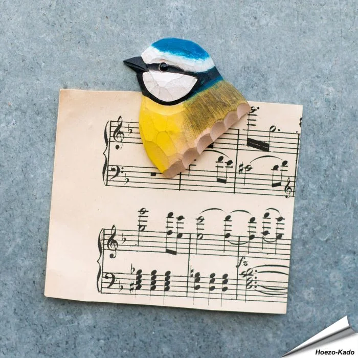 Ein Kühlschrankmagnet mit naturgetreu dargestelltem Vogelkopf, von Hand geschnitzt und bemalt.